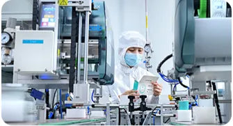 Worker in lab coat and mask inspects Sibionics blood glucose monitor on automated production line. Keywords: Sibionics, blood glucose monitor, production, quality control.
